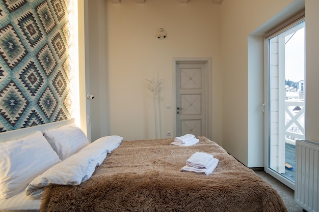 Интерьер просторной гостиничной спальни со свежим бельем на большой двуспальной кровати Уютная современная комната в современном доме