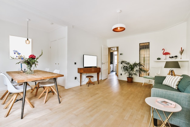 Interior of spacious light flat with retro furniture in dining and lounge areas