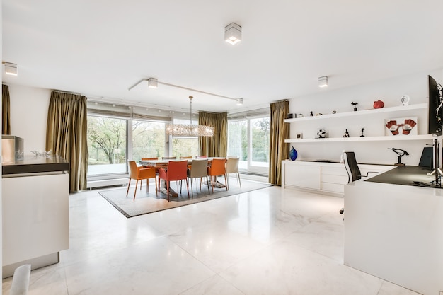 Interior of spacious light room with dining area and workspace in modern apartment