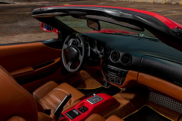 Interior of a sports car with luxury finishes showing the\
steering wheel speedometer tachometer seats