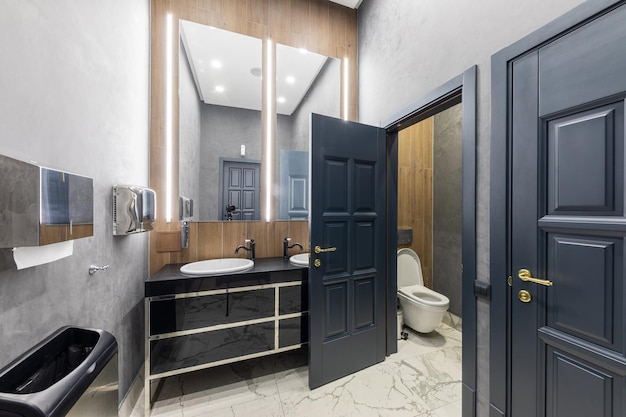 L'interno di un elegante e costoso bagno realizzato in un design moderno con un grande lavandino in grigio nero