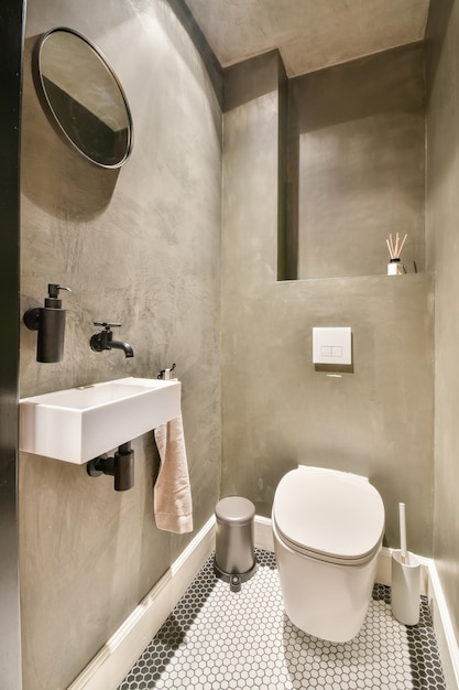 The interior of a toilet with a sink and a mirror above it