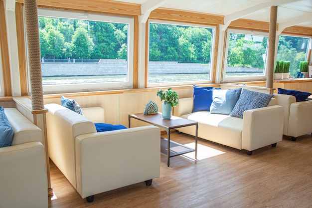 The interior of the urban river ship, with a panoramic view of the urban landscape. The concept of tourism, recreation, walking around the city, rest in the city. River transport.