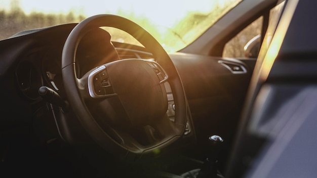 Interior view of car at sunset. Close up of steering wheel