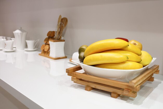 Photo interior of white kitchen with fruit on the table