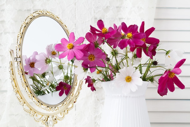 Interior with mirror and a table with a vase and flovers