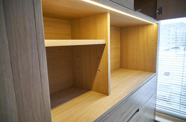 Photo interior wooden cupboard with empty shelves drawers and led lights modern furniture