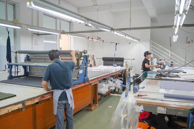 Interno di un laboratorio per cucire vestiti e tessuti ritratto di sarta professionista