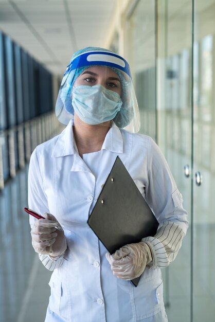 Intern nurse with a face shield showing at positive test tube