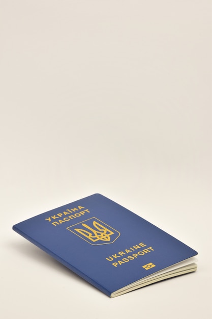 Internationaal paspoort van burgerschap van Oekraïne close-up op een witte achtergrond aan de onderkant van het frame ligt zijwaarts
