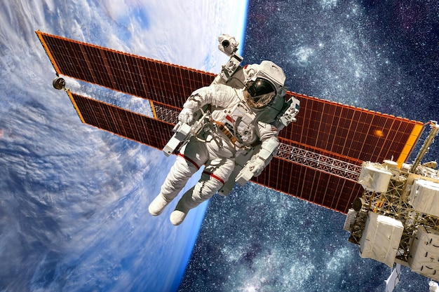 Internationaal ruimtestation en astronaut in de ruimte boven de planeet aarde. Elementen van deze afbeelding geleverd door NASA.