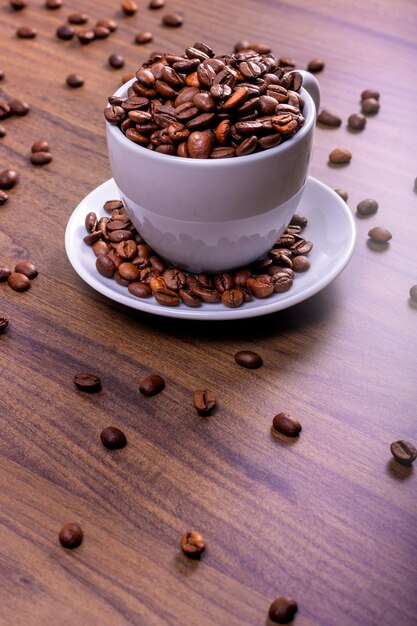 International coffee day concept Bowl overflowing with coffee beans on wooden table