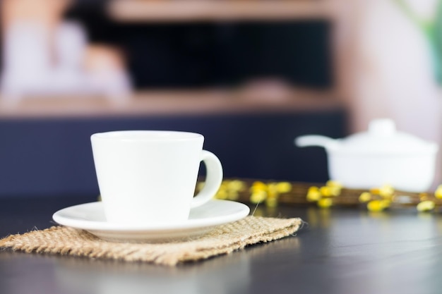 Giornata internazionale del caffè tradizionale bevanda colombiana primo piano della tazza di caffè sul tavolo da cucina nero decorato con fiori sullo sfondo