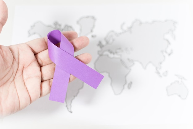 International Day for the Elimination of Violence Against Women hand with violet ribbon symbol