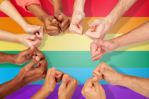 международное, разнообразие, гей-гордость, толерантность и концепция людей - руки показывают большие пальцы на фоне радуги