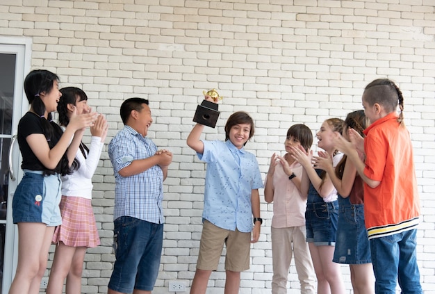 International elementary school girls and boys congratulate their peers for receiving the Outstanding Student Award