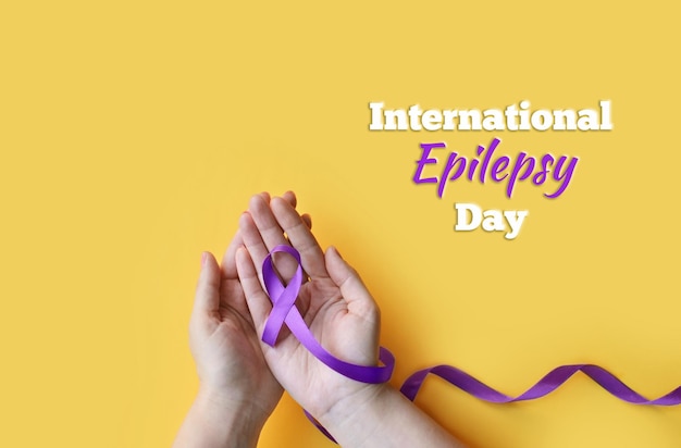 Photo international epilepsy day adult hands holding purple ribbon alzheimers disease