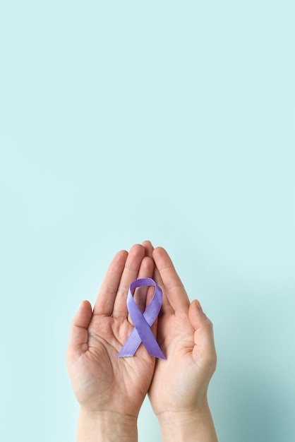 Photo international epilepsy day adult hands holding purple ribbon alzheimers diseasepancreatic cancer