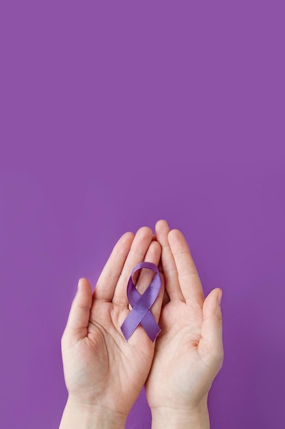 Photo international epilepsy day adult hands holding purple ribbon alzheimers diseasepancreatic cancer