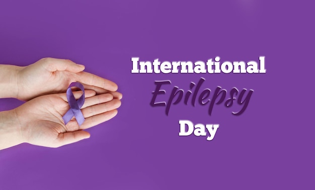 International epilepsy day adult hands holding purple ribbon on
purple background