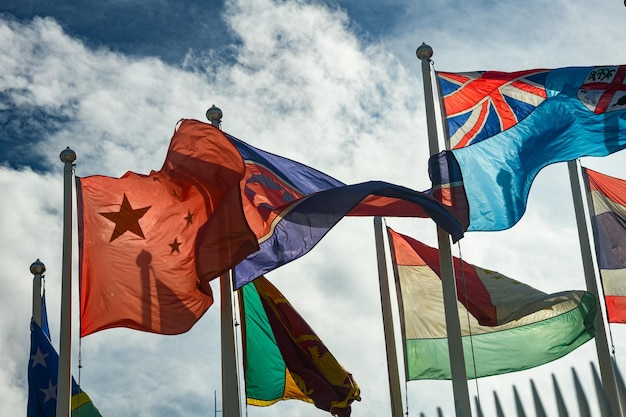 Фото Международная ассоциация флагов в ветре, качающейся с голубым небом и облаками.