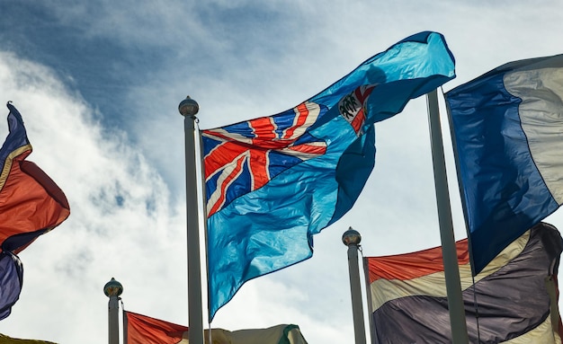 Foto associazione internazionale di bandiere nel vento oscillante con cielo blu e nuvole