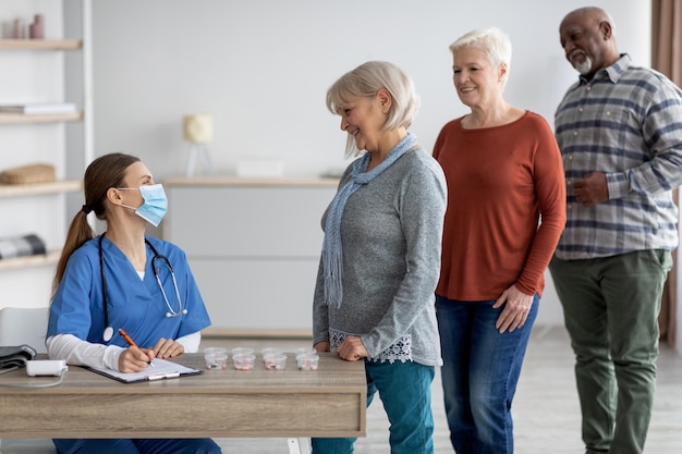 International group of senior people taking medicine in retirement house