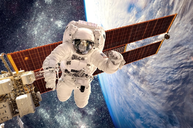 Photo international space station and astronaut in outer space over the planet earth. elements of this image furnished by nasa.