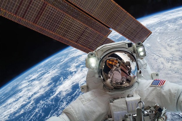 국제 우주 정거장과 행성 지구의 우주 공간에서 우주 비행사. NASA에서 제공한 이 이미지의 요소입니다.