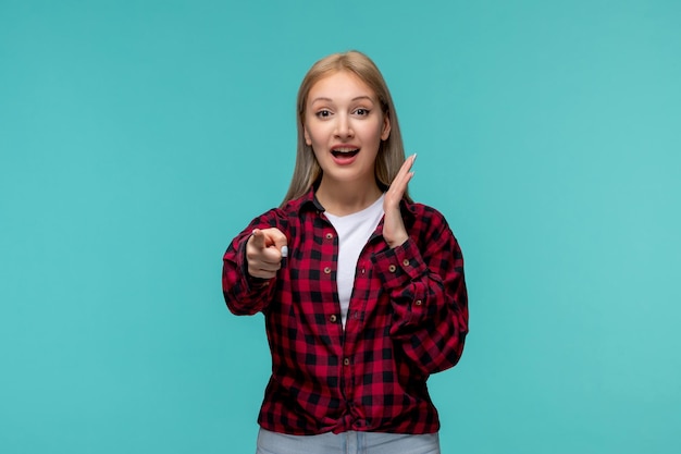 Giornata internazionale degli studenti bella ragazza carina in camicia rossa a quadri che punta sorprendentemente davanti