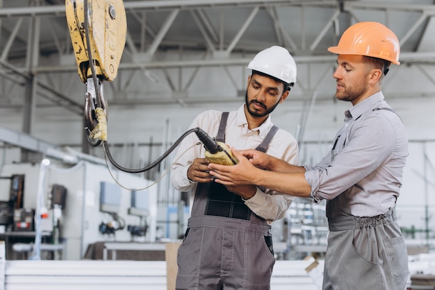 An international team factory workers operate the lift