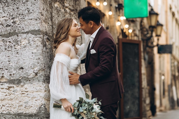 An international wedding couple a European bride and an Asian groom walk around the city together