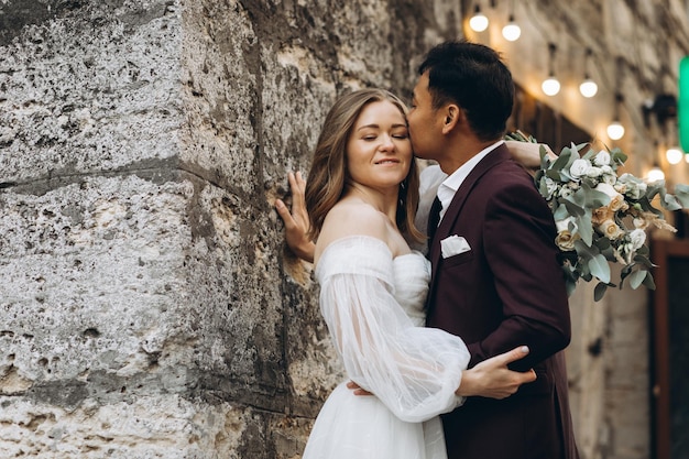 An international wedding couple a European bride and an Asian groom walk around the city together