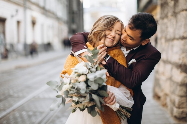 An international wedding couple a European bride and an Asian groom walk around the city together