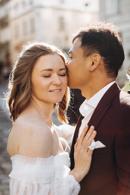 An international wedding couple a European bride and an Asian groom walk around the city together