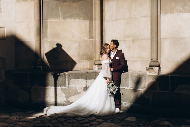 An international wedding couple a European bride and an Asian groom walk around the city together