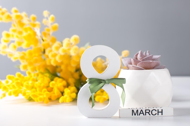 International Womens Day is March 8th A bouquet of mimosa a spring bouquet of flowers and a greeting card