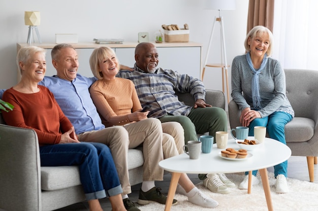 Internationale groep ouderen die tv kijken in verpleeghuis