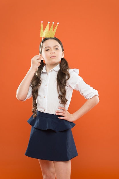 Internationale kinderdag Superieure prinses Fotohokje rekwisieten Speelse prinses Schoolmeisje prinses gouden kroon Koningin van de klas Narcistisch complex Geluk en vreugde concept Meisje met plezier