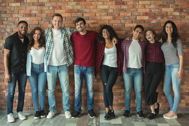 Internationale vriendschap en tolerantie. Vrolijke multi-etnische vrienden lachen en omhelzen, poseren voor groepsportret, kopiëren ruimte