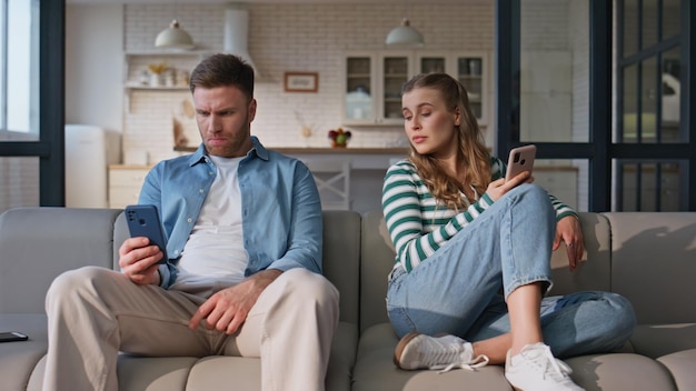 インターネット中毒の友達がスマートフォンをブラウジングしている 家庭の週末 怒られたカップル