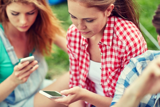 인터넷 중독, 기술 및 사람 개념 - 캠핑에서 스마트폰을 사용하는 친구 그룹