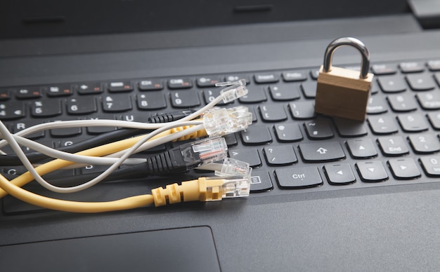 Photo internet cables with a padlock on the laptop