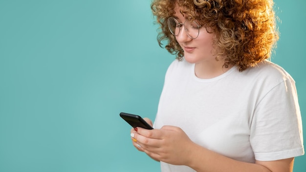 Internet chatten Online communicatie Afstand relatie Lichaam positief Tevreden lachende overgewicht vrouw met krullend haar telefoon SMS geïsoleerd op blauwe kopie ruimte