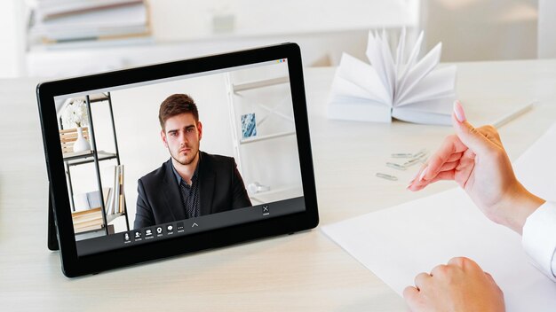 Foto internet videoconferenza ufficio cooperazione a distanza uomo d'affari fiducioso sullo schermo del tablet a