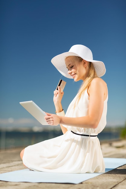 インターネットとライフスタイルの概念-屋外でオンラインショッピングをしている帽子の美しい女性