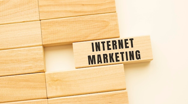 Internet marketing text on a strip of wood lying on a white table