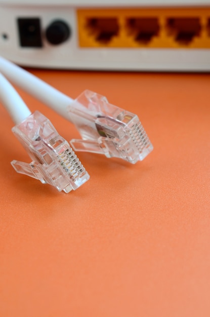 Photo internet router and internet cable plugs lie on a bright orange background. items required for internet connection