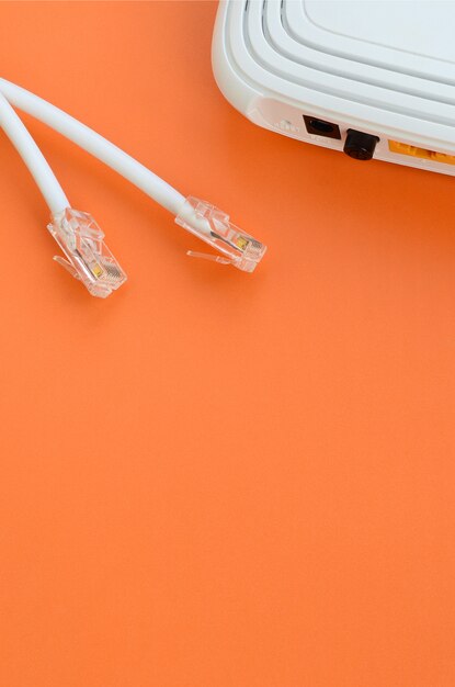 Internet router and Internet cable plugs lie on a bright orange background. Items required for Internet connection