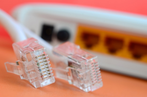 Internet router and Internet cable plugs lie on a bright orange background